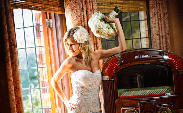 Round bouquet ties in with large flower in hair and soft off-white gown. Image provided by Hulse Photography