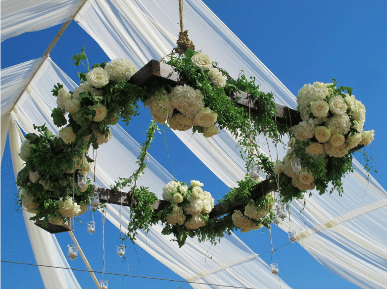A wooden frame supports flowers, greenery and candles Image provided by Organic Elements Event Design