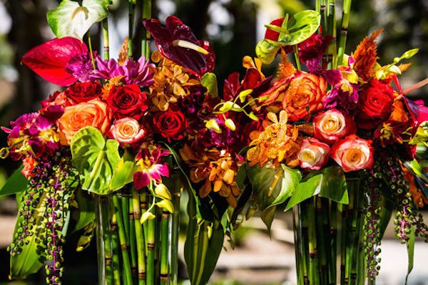 A mix of bright blossoms and tropical greens, creates a stunning arrangement. Image provided by Lois Mathews Floral Design Photography by Kristina Chartier Photography